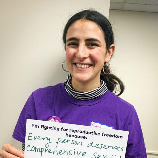 Gabbi Nazari holding paper that says every person deserves comprehensive Sex Ed