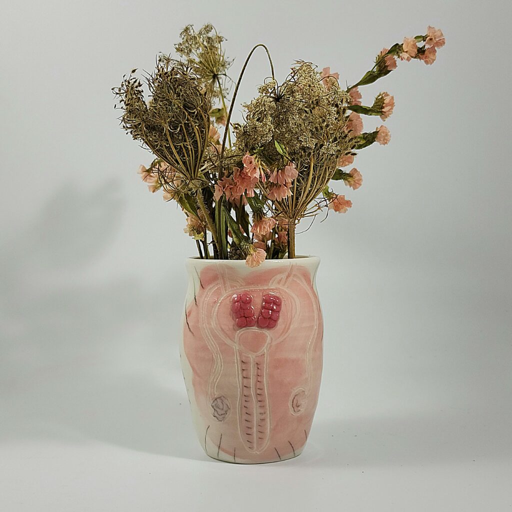 A pink vase with dried flowers created by nicole gugliotti.